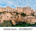 scenic travel landscape of beautiful historic town Tropea in Italy with old antique buildings, vintage houses on a high rock cliff above sea and amazing blue sky on background