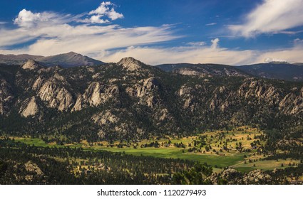 Scenic valley and snow-covered peaks under a blue sky with clouds in Estes Park, Colorado near the Rocky Mountain National Park. Aerial view from summit of Prospect Mountain. - Powered by Shutterstock