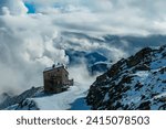 Scenic view of alpine hut Hannoverhaus in Ankogel Group, High Tauern National Park, Carinhtia, Austria. Hiking trail on snow covered alpine terrain in Austrian Alps. Cottage in remote mountain area