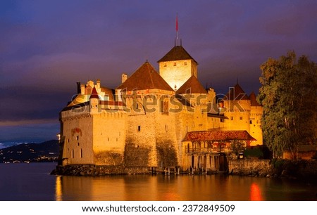 Scenic view of architectural complex of fortified Chillon Castle on Lake Geneva at summer dusk, Switzerland