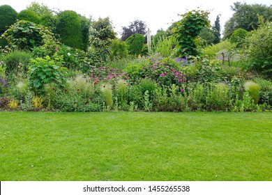 Scenic View of a Beautiful English Style Landscape Garden with a Green Mowed Lawn and Colourful Flower Bed - Shutterstock ID 1455265538