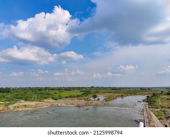 Scenic View Of Bennithora River, Small Walk Way Or Pathway In The Middle Of The River, Vehicles Moving Forward. Few People Standing On Roadway, Blue Sky With White Clouds On Background Bright Sunlight