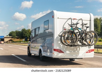 Scenic view big modern white family rv camper van vehicle driving on european highway road against blue sky in summer day. Rving motorhome lifestyle travel and adventure tourism trip journey concept - Shutterstock ID 2182125089