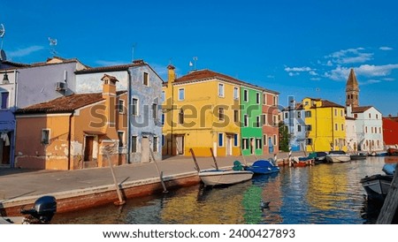 Scenic view of bright colorful houses on island of Burano in city of Venice, Veneto, Northern Italy, Europe. Cruising around the Venetian Lagoon. Water canal along idyllic riverbank. Summer tourism