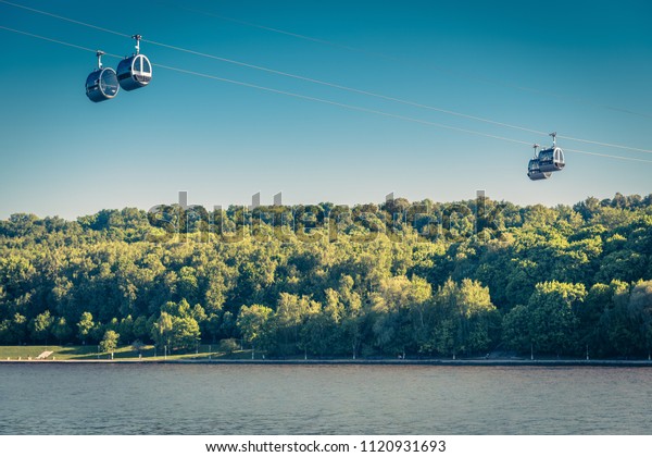 Scenic view of the cable car between Sparrow\
Hills and Luzhniki Stadium in Moscow, Russia. Cableway cabins hang\
in the sky above Moskva River in Moscow. Luzhniki park is a sport\
landmark of Moscow.