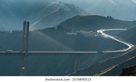 A scenic view of the cable-stayed bridge spanning across lush green mountains under a clear blue sky.