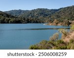 Scenic view of calm water of Stevens Creek Reservoir on a clear sunny day, at Stevens Creek County Park, Cupertino, California, Silicon Valley, San Francisco Bay Area