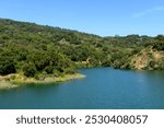 Scenic view of calm water surface of Stevens Creek Reservoir at full capacity in Santa Clara County.