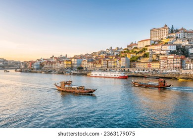 Scenic view of the city of Porto in Portugal in warm winter sunset light with boats and Douro river in foreground  - Powered by Shutterstock