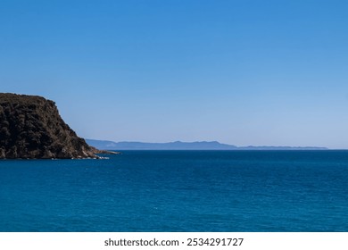 Scenic view of coastline of Himare, Vlore, Albanian Riviera, Albania. Clear blue sky, calm turquoise water, rocky headland extend into Ionian Mediterranean sea. Distant Corfu island. Summer vacation - Powered by Shutterstock