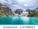 A scenic view of the Colchuck Lake against blue sky in bright sunlight in Chelan County, Washington, United States