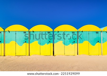Scenic view of colored beach cabins at the beach in Dunkirk, France against blue summer sky