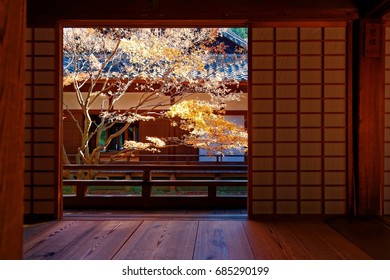 Scenic view of a colorful maple tree in the courtyard garden behind the sliding grid doors (shoji) of a traditional Japanese architecture in Shoren-In (青蓮院), a famous Buddhist temple in Kyoto, Japan
