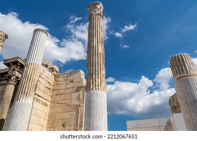 Scenic View Of The Columns Of The Ruined Library Of Hadrian In Athens, Attica, Greece, Europe. Corinthian Columns Of The Propylon Of Pentelic Marble. Ruins Of Ancient Agora, Birthplace Of Democracy