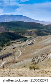 Scenic View Of Dirt Road And Farmhouses In A Mountain Ravine