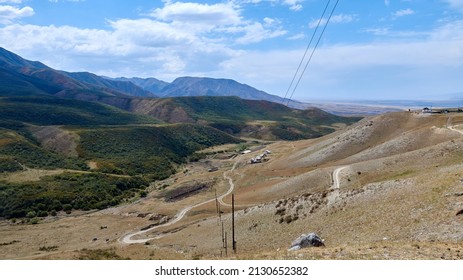 Scenic View Of Dirt Road And Farmhouses In A Mountain Ravine