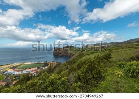 Scenic view of the dramatic coastal cliffs and football field at Fajã de Lopo Vaz on Flores Island, Azores, overlooking the blue Atlantic Ocean