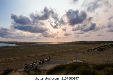 A scenic view of a dramatic sunset over a low tide island