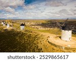 Scenic view from drone of ancient windmills and castle ruins atop Cerro Calderico ridge, Consuegra, Spain