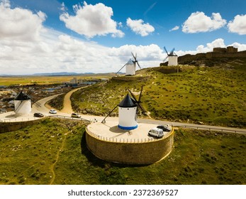Scenic view from drone of ancient windmills and castle ruins atop Cerro Calderico ridge, Consuegra, Spain