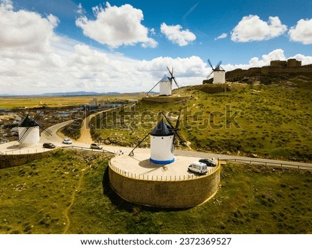Scenic view from drone of ancient windmills and castle ruins atop Cerro Calderico ridge, Consuegra, Spain