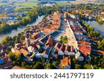 Scenic view from drone of historic part of Czech town of Telc with brownish tiled roofs of houses and medieval Castle surrounded by ponds..