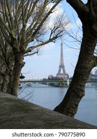 Scenic View Of The Eiffel Tower Between Plane Trees In Spring, Seen From The Quai Louis Blériot Across The Seine River. 