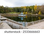 A scenic view of the El Bosque de Bejar Garden in Bejar, Salamanca, Castilla y Leon, Spain. A beautiful fountain surrounded by lush greenery.