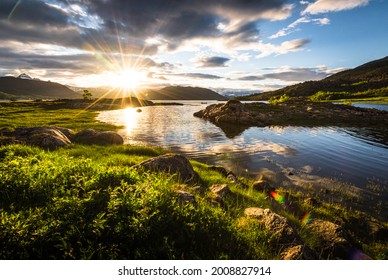 Scenic view of fjord landscape in northern norway with warm midnight sun in late spring with green grass and nature - Shutterstock ID 2008827914