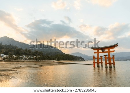 Scenic view of floating torii gate at sunset by ocean