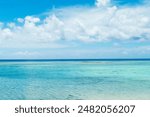A scenic view of fluffy white clouds over sandy Tumon Beach, Guam, USA
