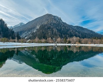 Scenic view of frozen lake Jezero Jasna in Kranjska Gora along road to Vrsic Pass in winter. Reflection of snow capped mountains of Julian Alps, Slovenia. Warm glow creates tranquil serene atmosphere - Powered by Shutterstock