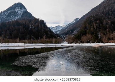 Scenic view of frozen lake Jezero Jasna in Kranjska Gora along road to Vrsic Pass in winter. Reflection of snow capped mountains of Julian Alps, Slovenia. Warm glow creates tranquil serene atmosphere - Powered by Shutterstock