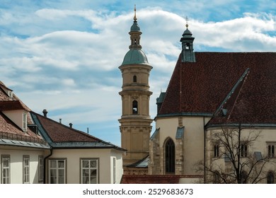 Scenic view of Graz Cathedral in Styria, Austria, Europe. Gothic-style cathedral with aprominent tower and red-tiled roof. Surrounded by other buildings and courtyard. Historic architecture of city - Powered by Shutterstock