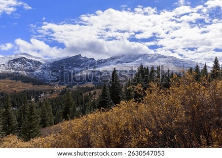 A scenic view of Guanella mountain pass with a forest landscape in cloudy sky background in Colorado