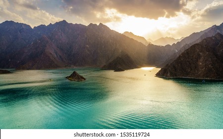Scenic view of Hatta Lake and Hajar Mountains in the Emirate of Dubai, UAE at sunset