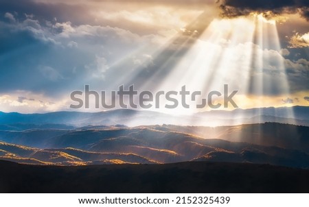 A scenic view of hills and mountains filled with evening sunrays