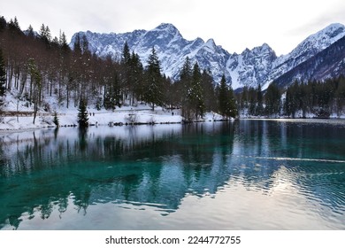 Scenic view of lago di fusine inferiore near Tarvisio in Friuli-Venezia Giulia region of Italy and Mangart mountain in Julian alps in winter - Shutterstock ID 2244772755