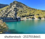 A scenic view of Lake Plastiras, an artificial lake fed by the Tavropos (Megdovas) River, located near the city of Karditsa, Greece. This popular resort offers serene natural beauty.