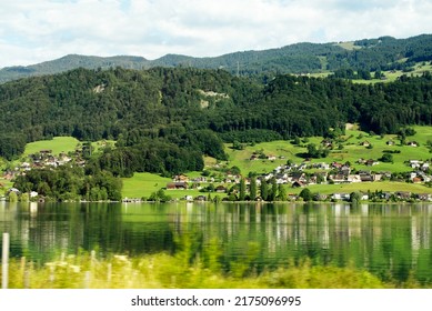 Scenic view of Lake Sarnen, Canton Obwalden, with meadows, houses and woodland on a sunny summer day. Photo taken July 3rd, 2022, Lungern, Switzerland.