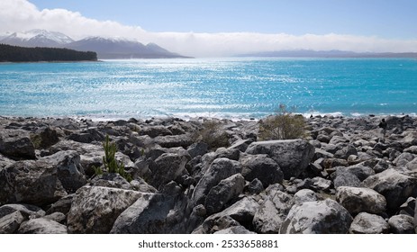 Scenic view of Lake Tekapo with turquoise waters and rocky shore in New Zealand - Powered by Shutterstock