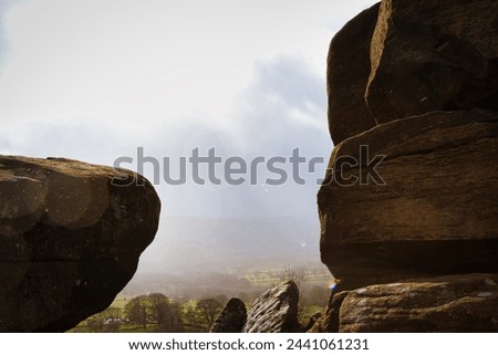 Scenic view of a landscape through rock formations under a cloudy sky at Brimham Rocks, in North Yorkshire