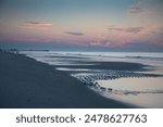 A scenic view of lingering tidal pools at Myrtle Beach, SC by the Apache Pier just before sunrise