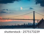 A scenic view of the Lions Gate Bridge with the moon rising over Vancouver