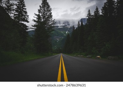 A scenic view of a long winding road leading towards a majestic mountain range. - Powered by Shutterstock