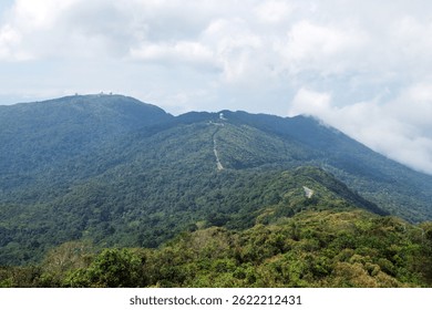 Scenic view of a lush green mountain range with a road winding through the hills. Prao, Vietnam.