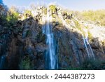 Scenic view of majestic waterfall Veliki Slap in magical Plitvice lakes National Park, Karlovac, Croatia, Europe. Powerful cascade between massive rock formations in green natural paradise. Wanderlust