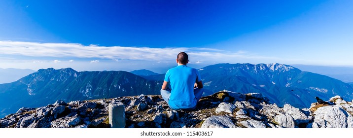 Scenic view of the man who meditates sitting on the cliff`s edge on the wide mountains landscape background. Velika Raduha, Slovenia. - Powered by Shutterstock