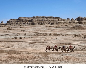 Scenic view of the massive wind eroded sandstone yardang formations at Urho Ghost City under a clear blue sky in Xinjiang, China.