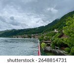 A scenic View of Merligen town, the mountains and homes on the lake in Switzerland. Seen from a tourist boat taking tourists around the lake.